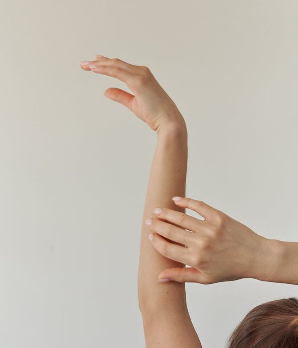 Woman in a graceful yoga pose with soft violet light accents.